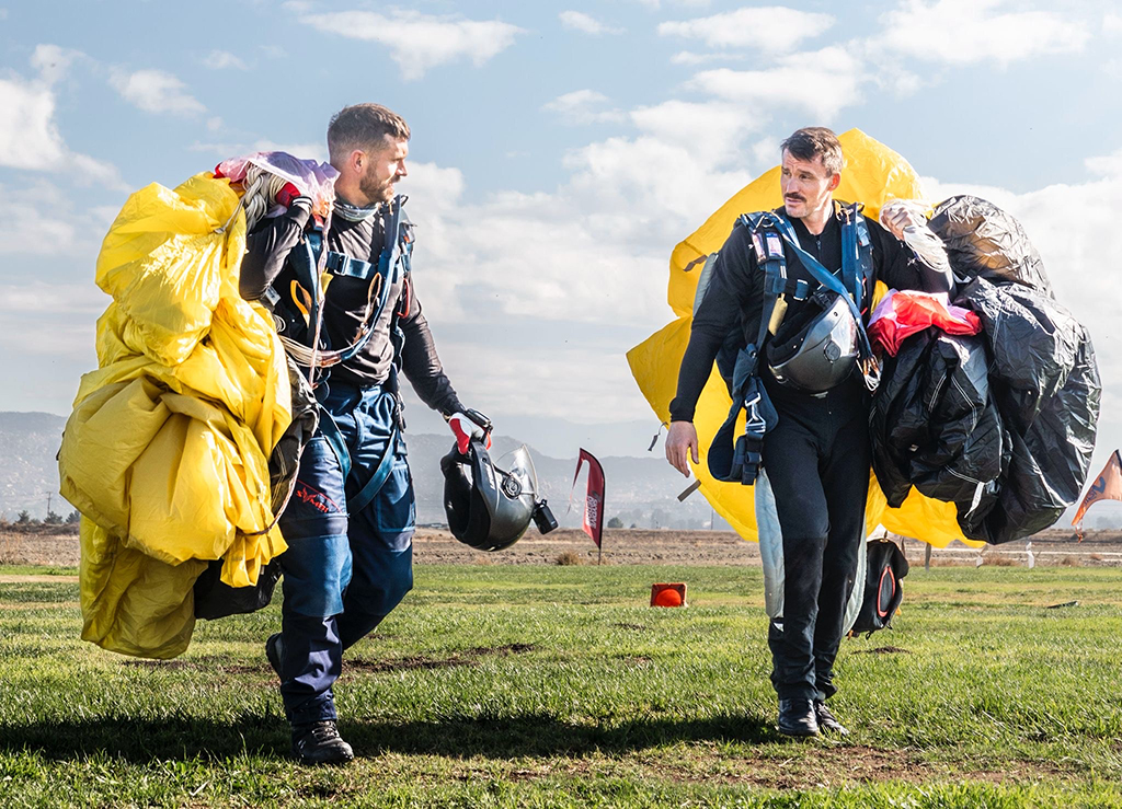 Corporal Higham (left) discusses the recent jump with another team member, as they walk of the landing zone together.